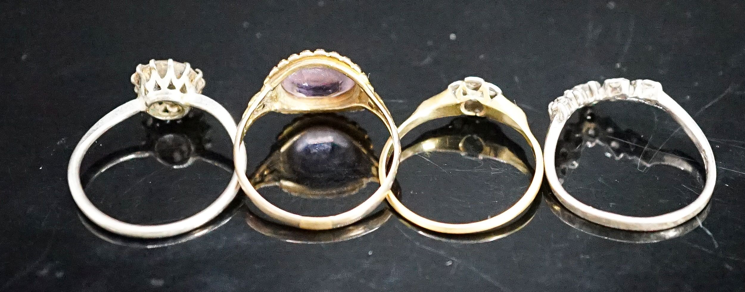 A Victorian yellow metal and amethyst dress ring (shank a.f.), gross 2.6 grams, size P/Q, a small diamond set ring(a.f.), gross 1.8 grams and two paste rings.
